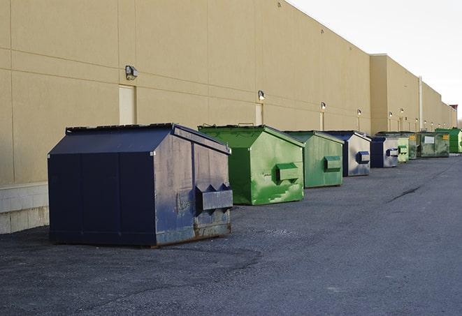 a pile of demolition waste sits beside a dumpster in a parking lot in Anna, OH